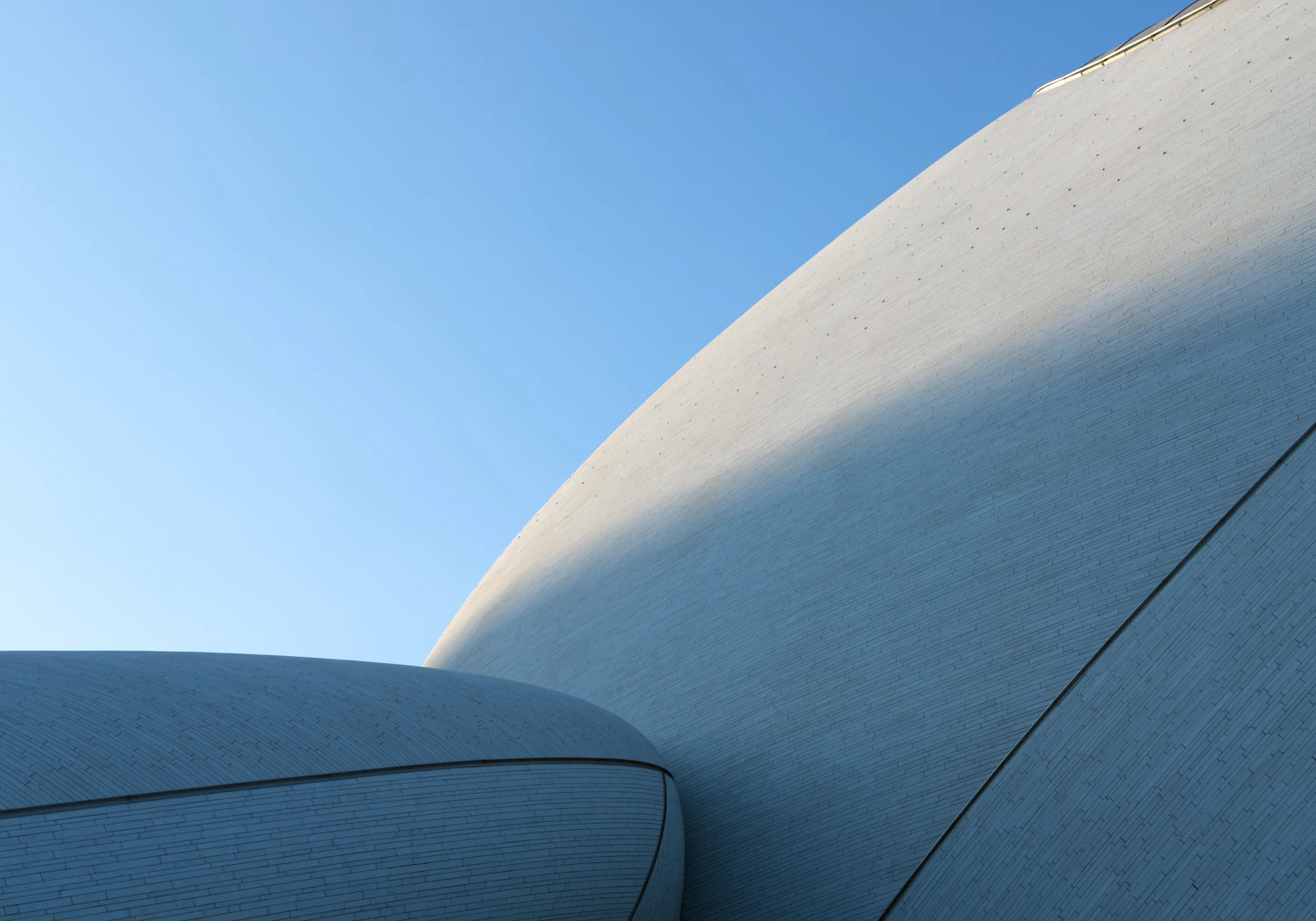 White curved architecture against a clear blue sky